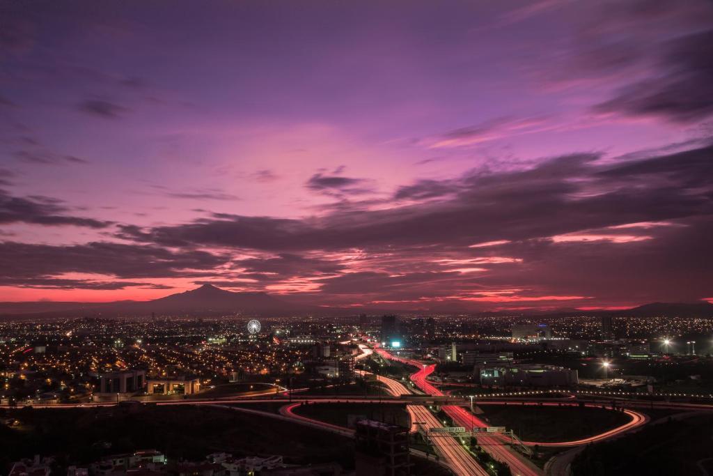 una vista di una città di notte con un cielo viola di Laviu B&B Luxe Suites a Puebla