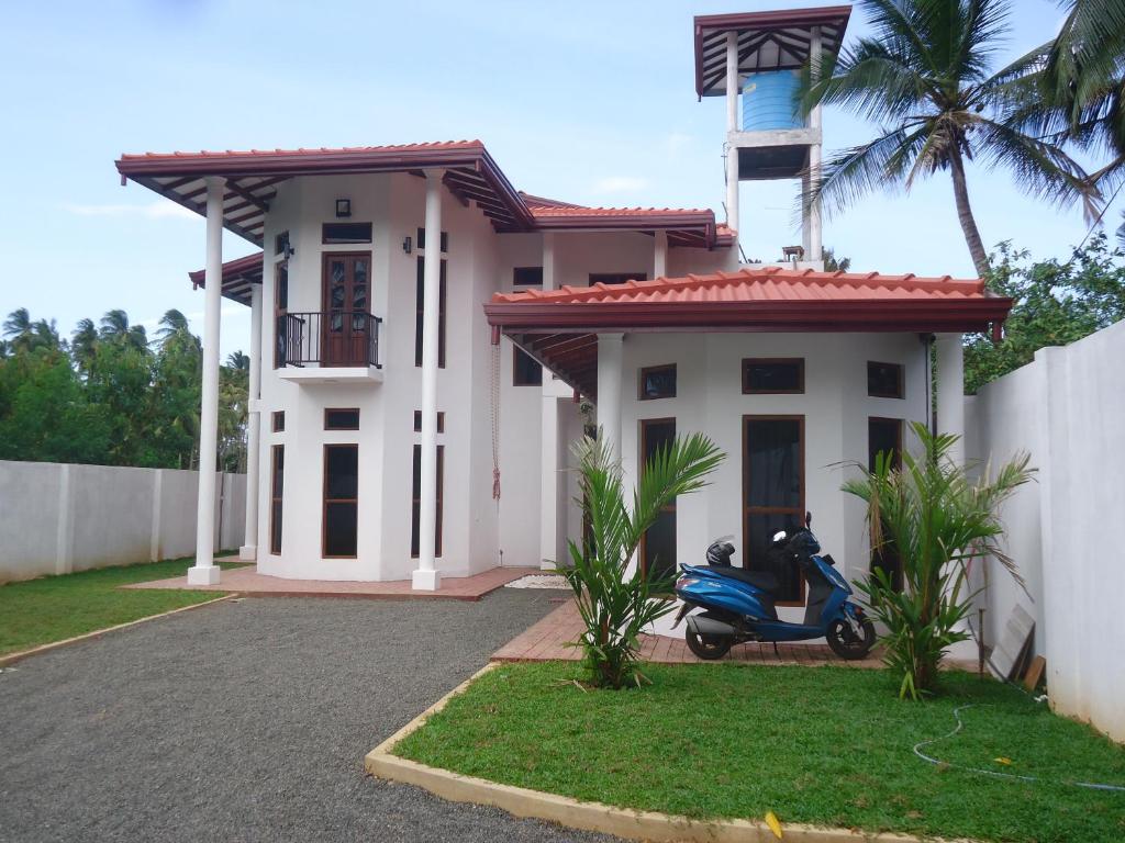 a scooter parked in front of a house at Amawin Resort in Hambantota
