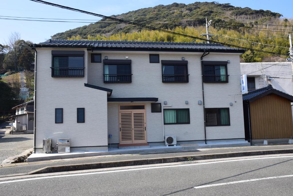 a white house on the side of a street at Minshuku Nishidomari in Tsushima