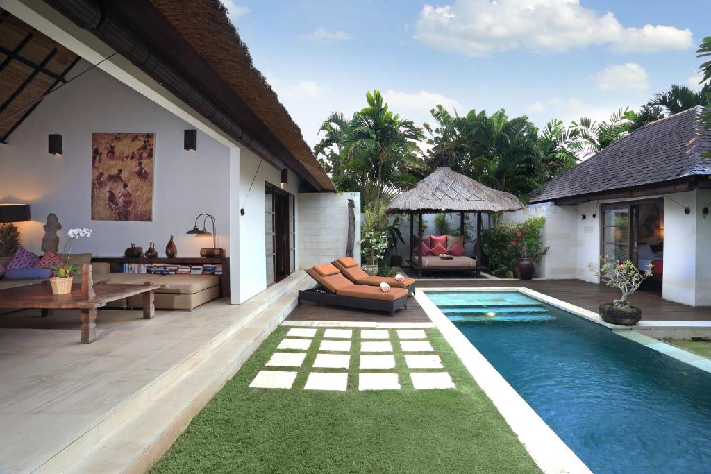 a backyard with a swimming pool and a villa at Villa Bali Asri in Seminyak