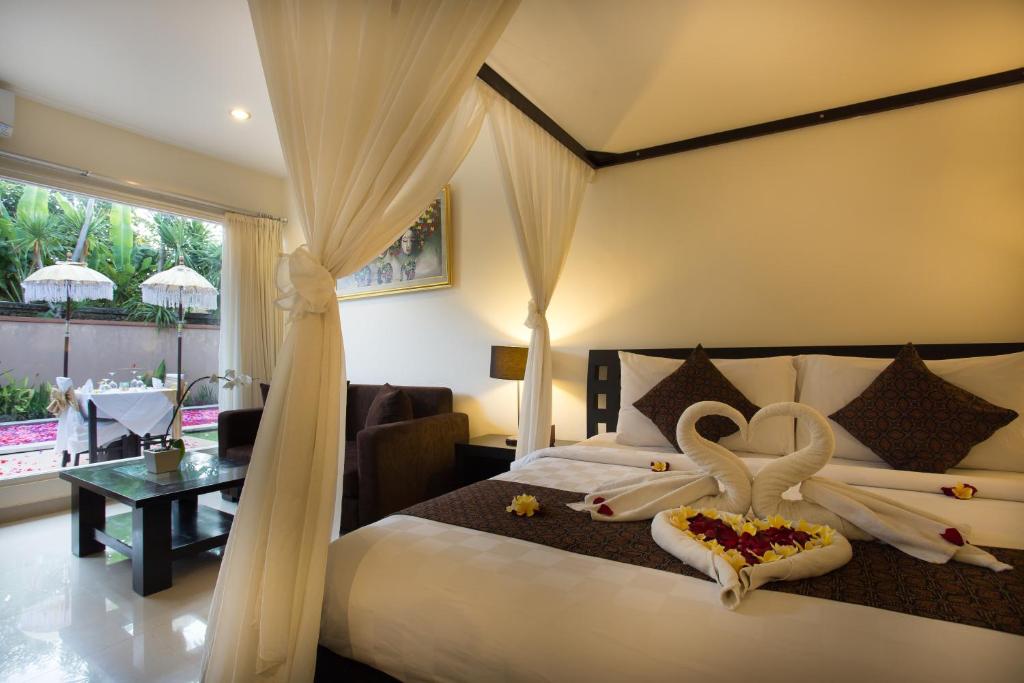 een slaapkamer met een bed met zwanen erop bij The Yubi Boutique Villas Seminyak in Seminyak