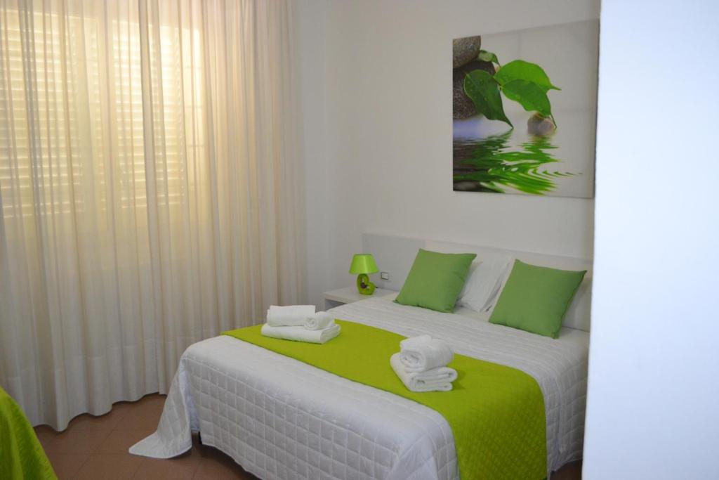 2 camas en una habitación con verde y blanco en Bed Happy, en Porto Cesareo