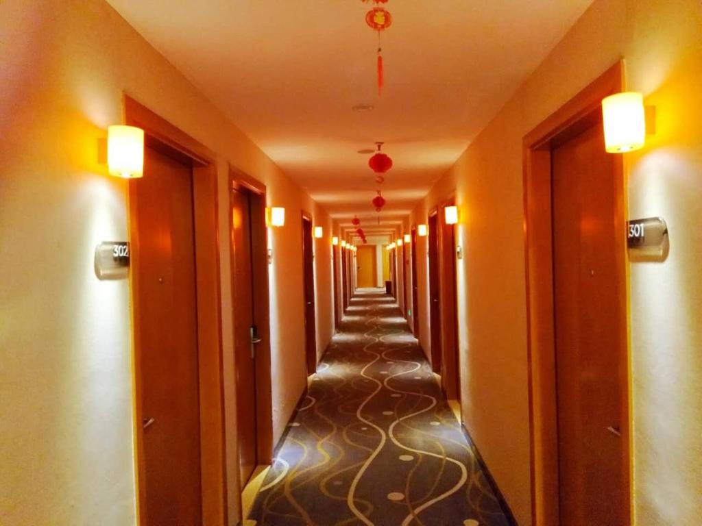 a hallway of a hotel with a long corridor at 7Days Premium Chongqing Airport Light Rail Huixing Station Branch in Chongqing