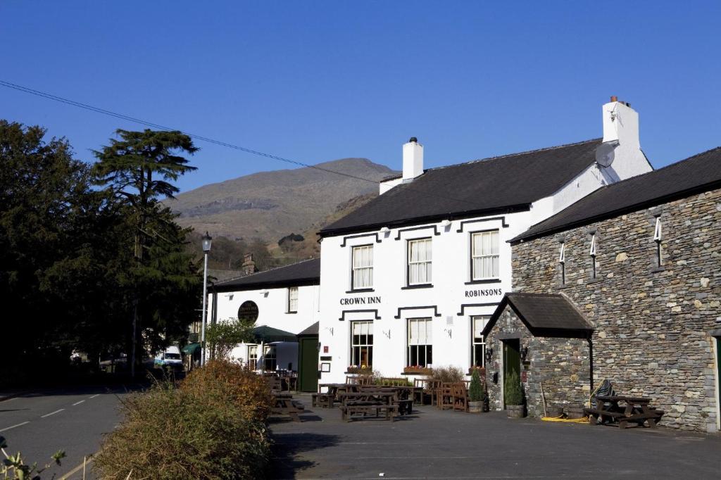 a large white building with tables in front of it at The Crown Inn in Coniston