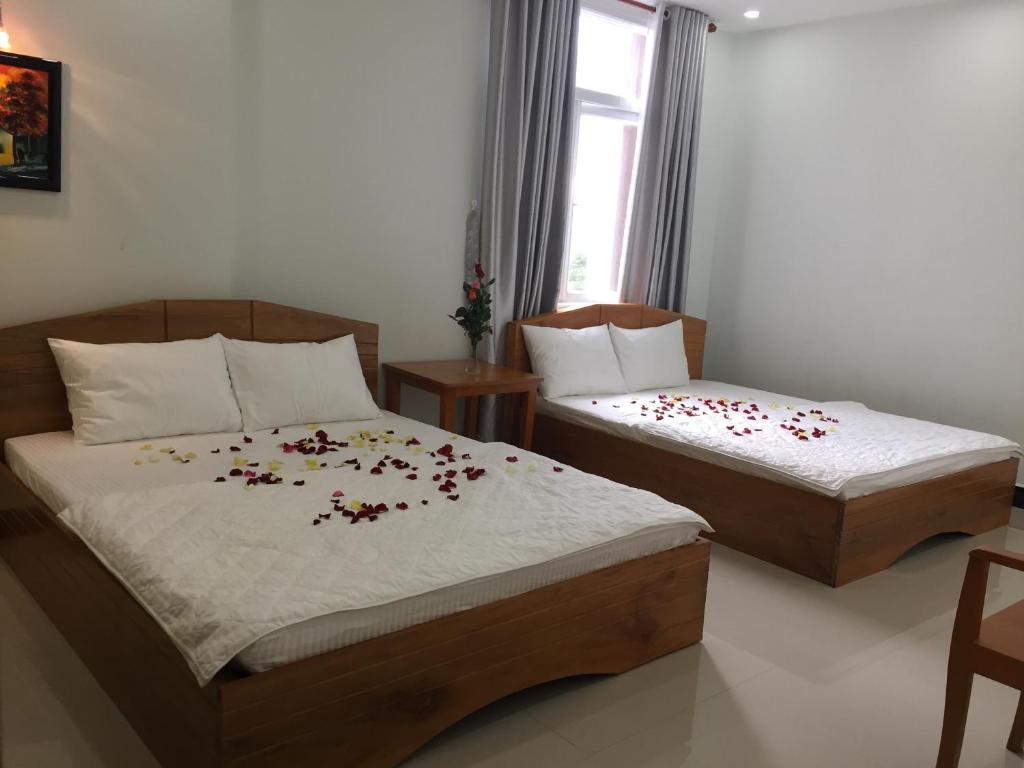 a bedroom with two beds with flowers on them at Thanh Lam Hotel in Tuy Hoa