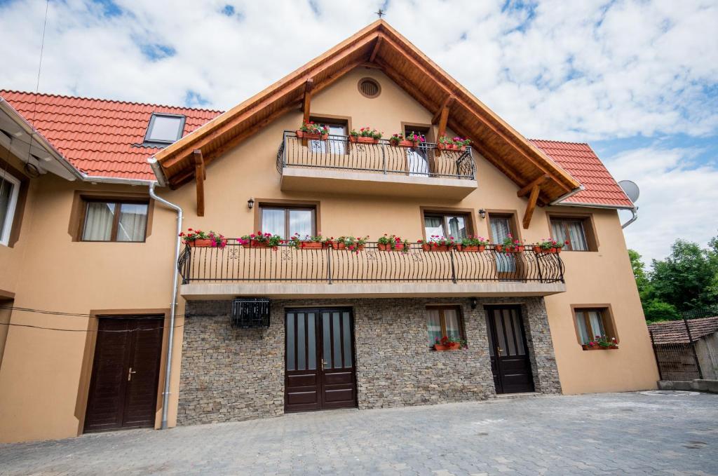 ein Haus mit Blumenkästen auf den Balkonen in der Unterkunft Sziklakert Fogadó in Sâncrai