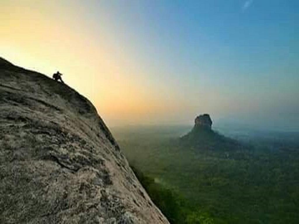 una persona parada en la cima de una montaña en Sigiriya Vee Guest, en Sigiriya