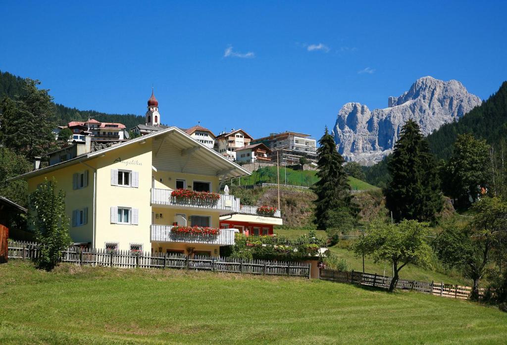 a house on a hill with mountains in the background at Haus Angelika in Nova Levante