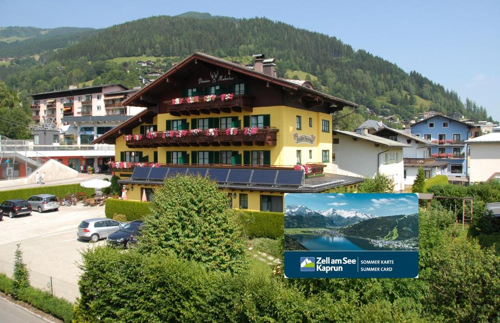 un bâtiment jaune avec un panneau devant lui dans l'établissement Hotel Pension Hubertus, à Zell am See