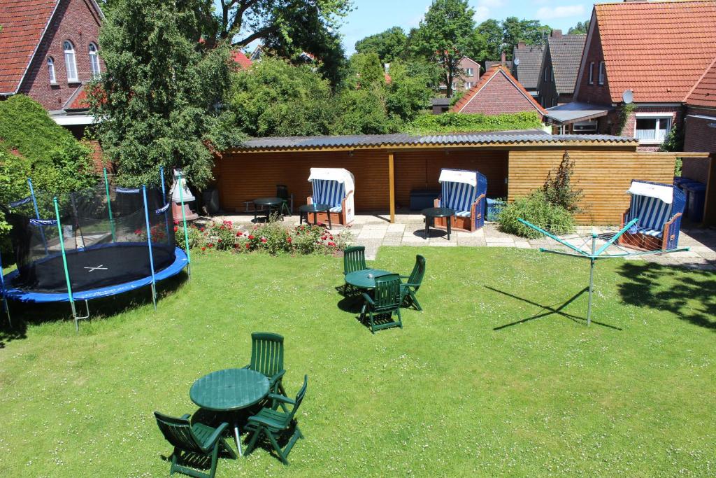 a backyard with a table and chairs and a pool at Ferienwohnanlage Lübben in Carolinensiel