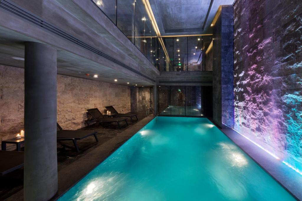 - une piscine dans une chambre dotée d'un mur en pierre dans l'établissement Endless Art Hotel-Special Category, à Istanbul