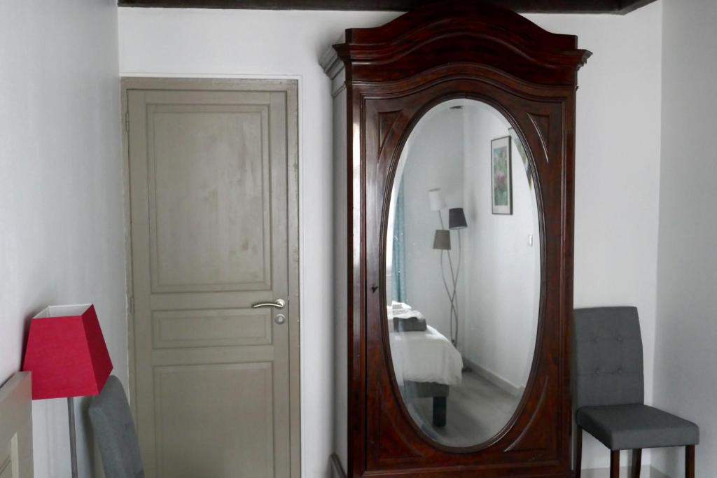 um espelho de madeira ao lado de uma porta num quarto em Domaine d'Adon em Adon