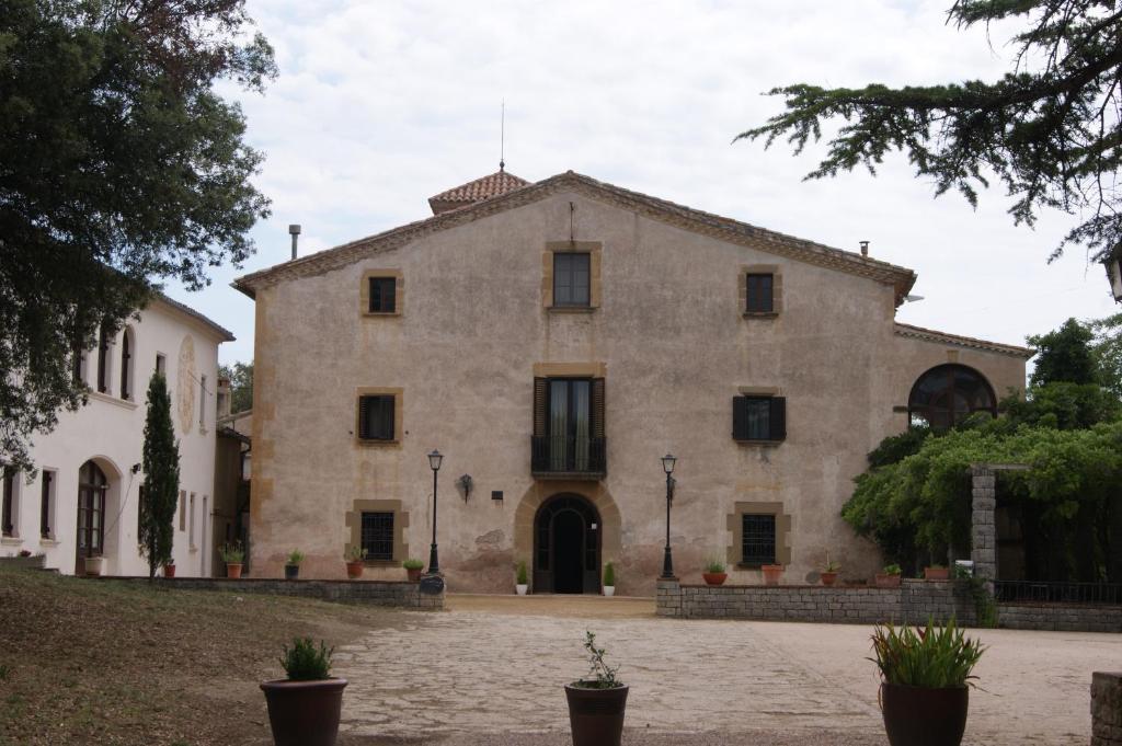 un gran edificio de piedra con patio en Hostal Rural Mas Blanc en San Martín de Centellas