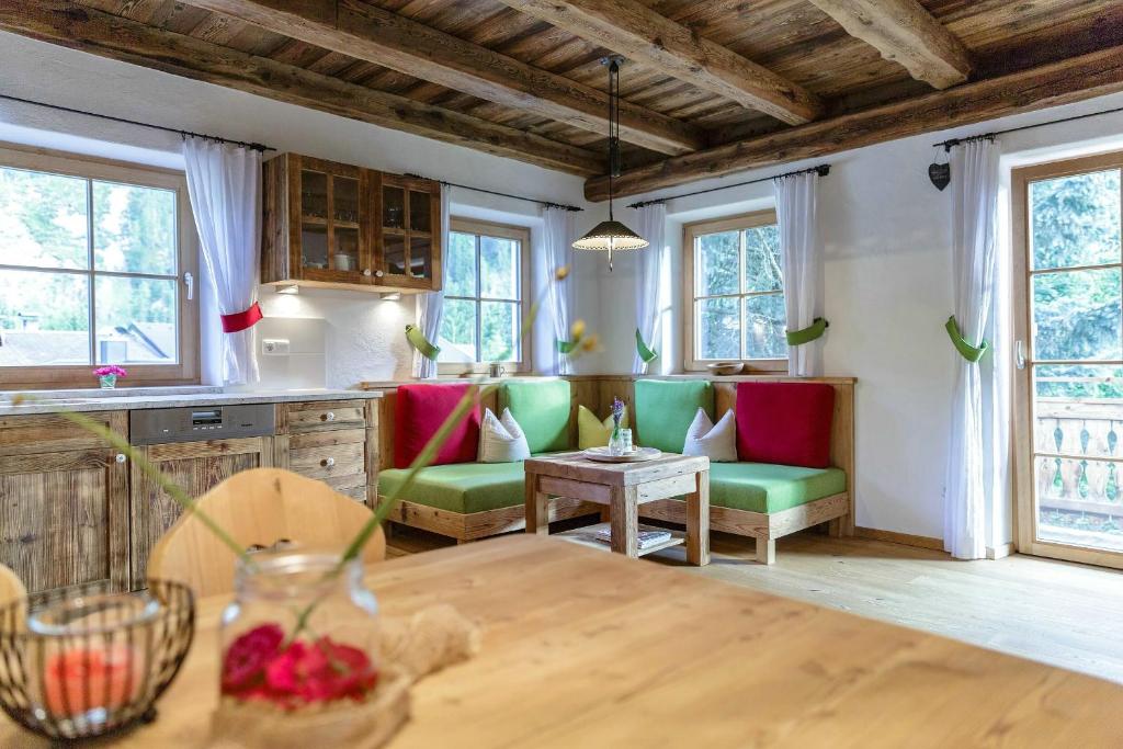 a kitchen with green and red chairs and a table at Residence Mitterdorfer in Abfaltersbach