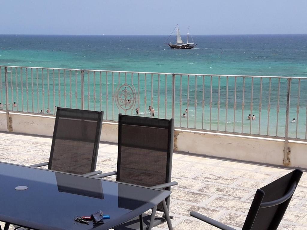 Una mesa y sillas con vista al mar. en Villa Capitolo, en Monopoli