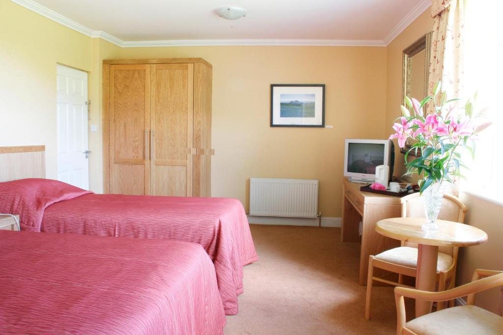 Postel nebo postele na pokoji v ubytování Ring of Kerry Hotel