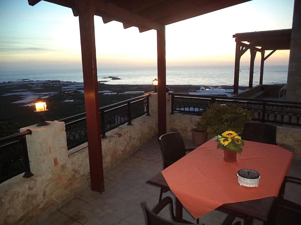 eine Terrasse mit einem Tisch und Meerblick in der Unterkunft Kavousi Traditional Home in Phalasarna