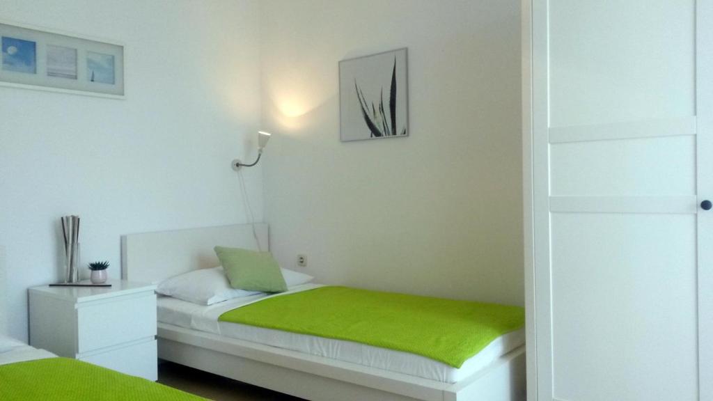 sypialnia z łóżkiem z zielonym kocem w obiekcie Apartment Zea w Novalji