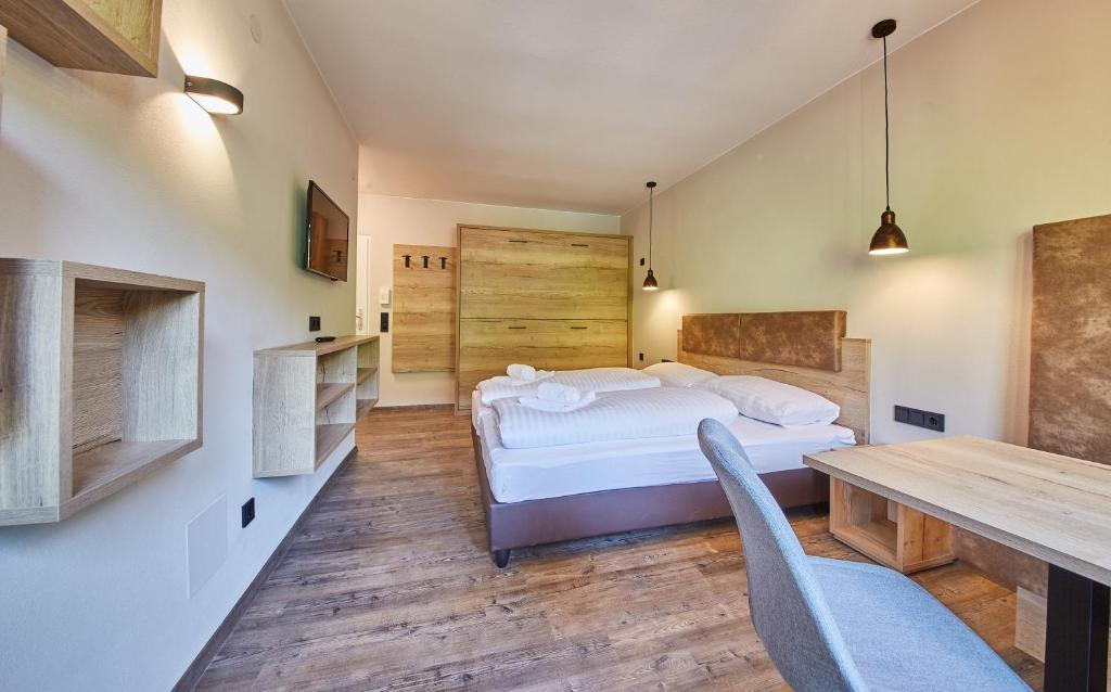 ザールバッハ・ヒンターグレムにあるAppartement Bella Vistaのベッドルーム1室(ベッド1台、テーブル、椅子付)