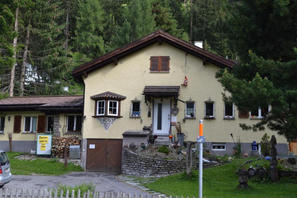 ein kleines gelbes Haus mit brauner Tür in der Unterkunft Bergheim Matta in Davos