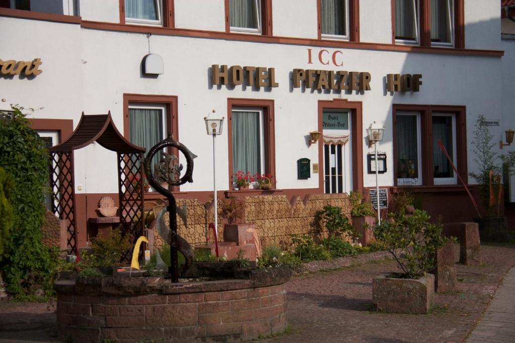 a hotel with a statue in front of a building at ICC Pfälzer Hof - Hotel & Seminarhaus in Schönau