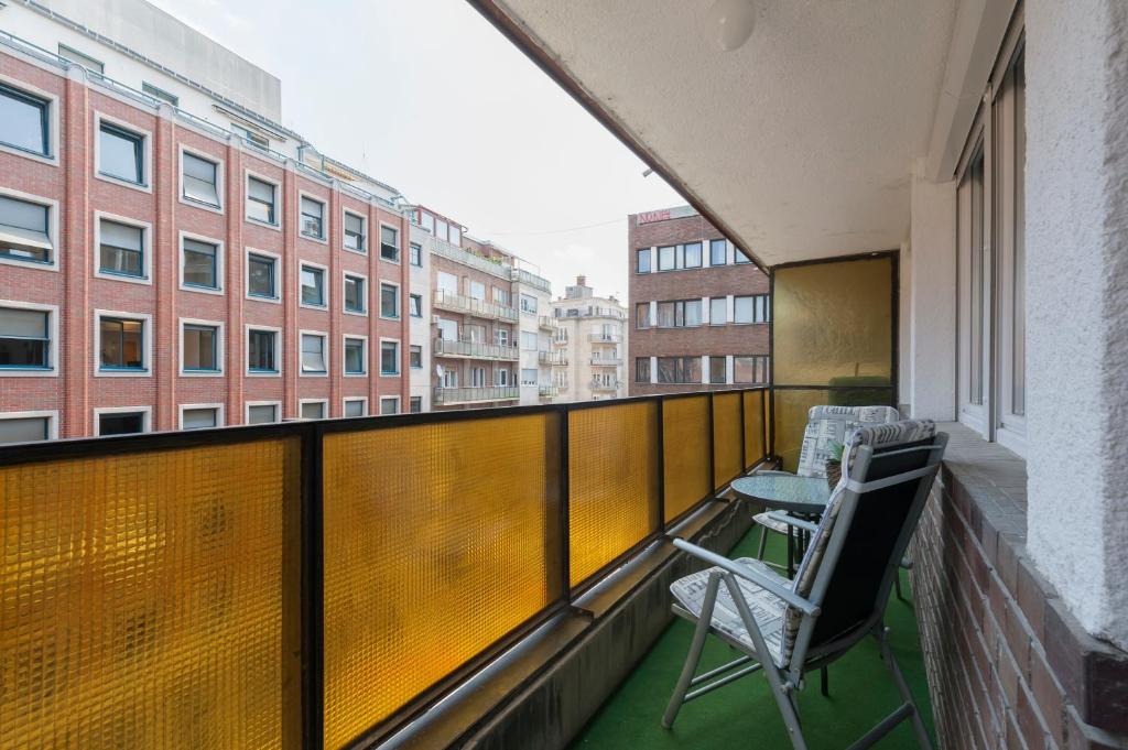 a balcony with two chairs and a table and buildings at Casa Tua3 in Budapest