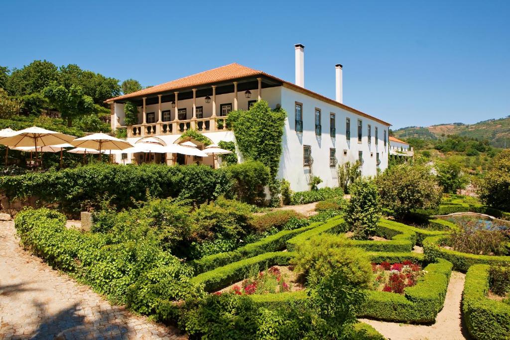 ein Gebäude mit einem Garten vor einem Gebäude in der Unterkunft Hotel Rural Casa dos Viscondes da Varzea in Lamego