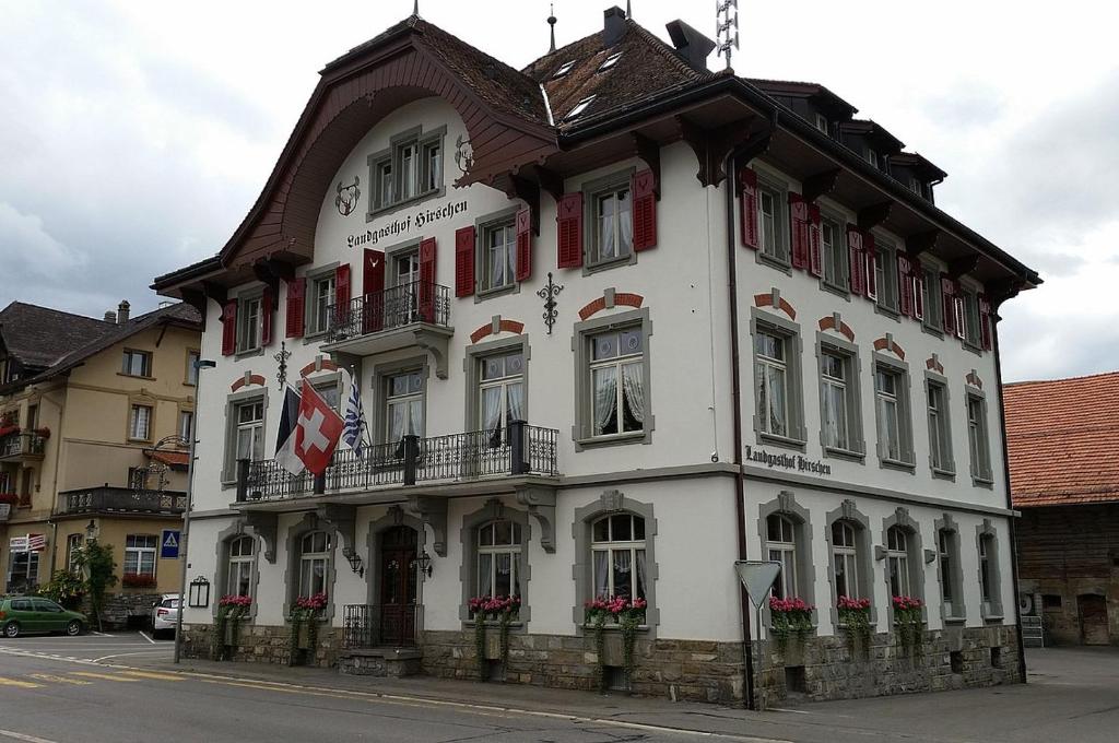 duży biały budynek z brązowym dachem w obiekcie Hotel Hirschen Plaffeien w mieście Plaffeien