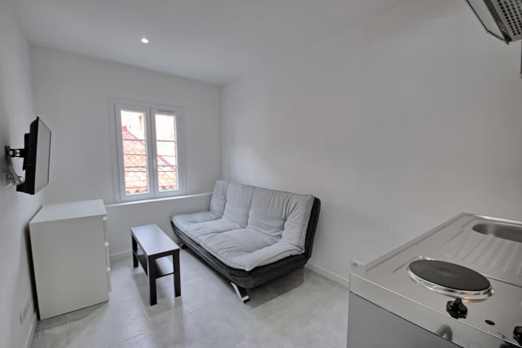 - un salon blanc avec une chaise et une table dans l'établissement 301-Studio au calme entierement renove, à Antibes