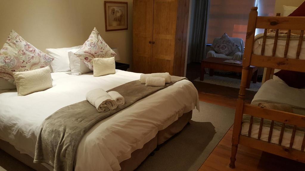 a bedroom with a bed with towels on it at Copperpot Guesthouse in Port Elizabeth