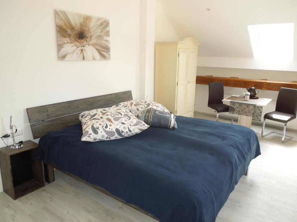 1 dormitorio con 1 cama, mesa y sillas en Weingut Nies, en Lorchhausen