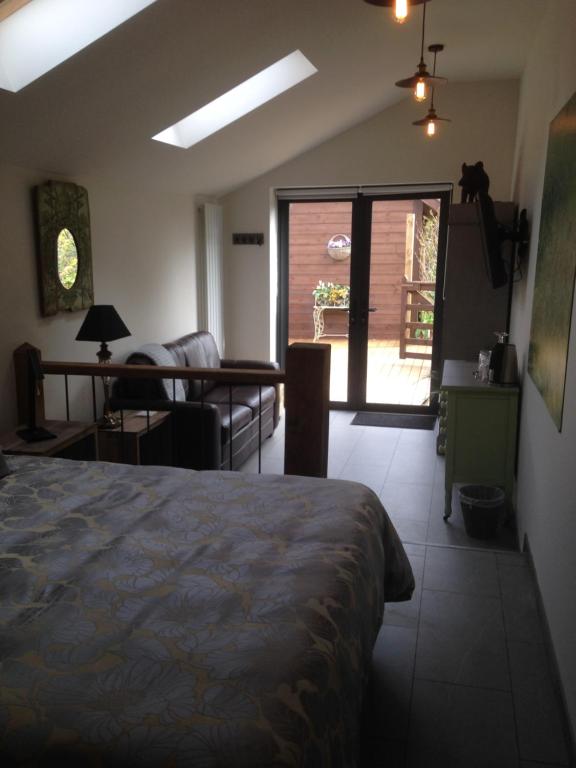 a bedroom with a bed and a living room at Pinetree Lodge Druridge Bay in Amble