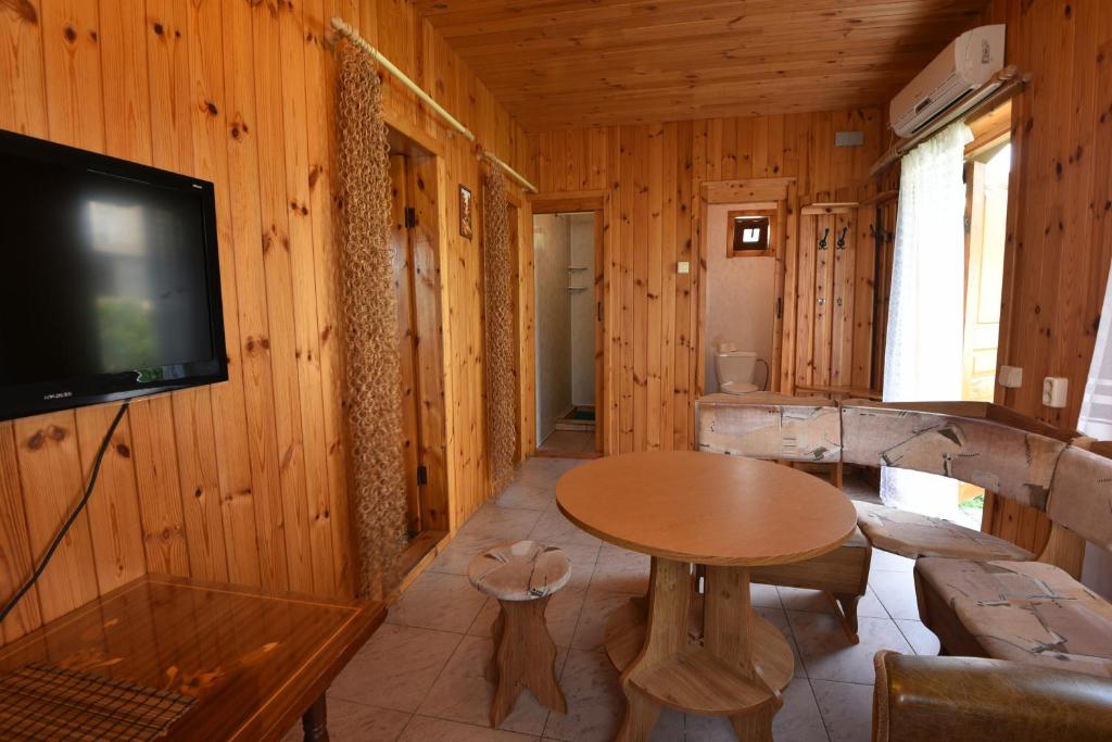 ゴルビツカヤにあるГостиный двор "ИриАнд"のキャビン内のテーブルとテレビ付きの部屋