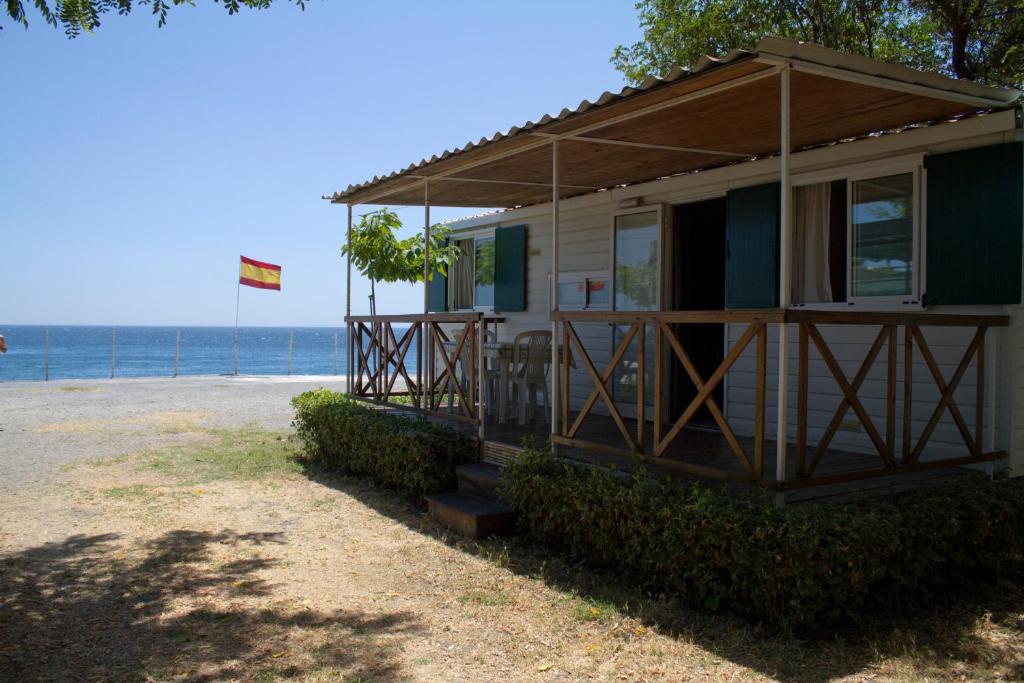 a house with a porch on the beach at Camping La Focetta Sicula in SantʼAlessio Siculo
