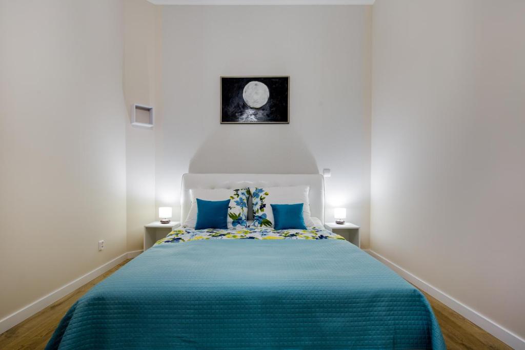 クラクフにあるKings Landing Apartamentのベッドルーム1室(青い毛布付きのベッド1台付)