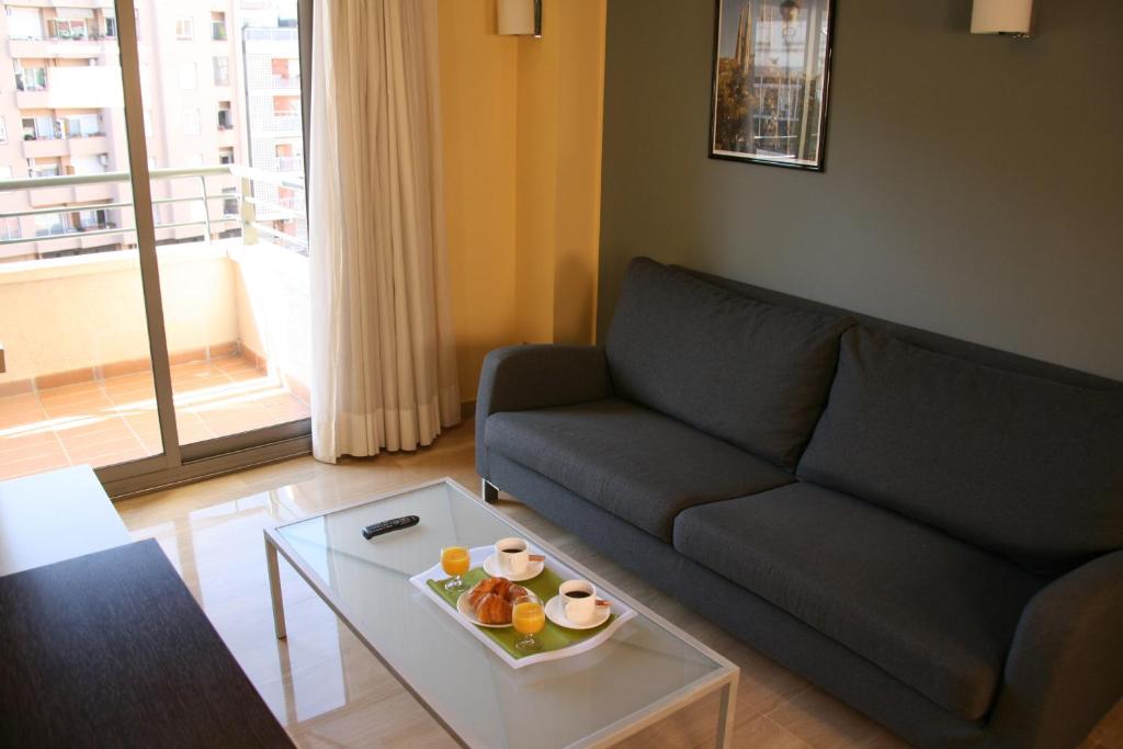 a living room with a couch and a table with a bowl of fruit at Apartaments Independencia in Barcelona