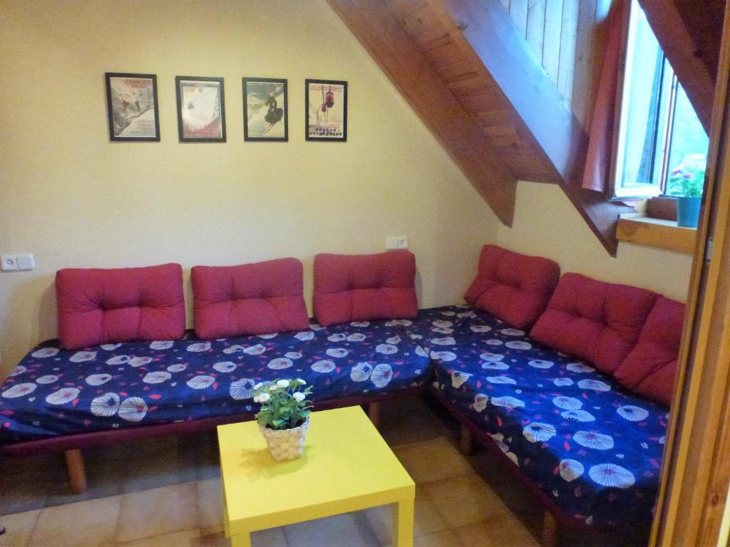 プラ・デ・ラ・エルミータにあるApartament Vall de Boi Taullの赤いクッションとテーブル付きのベッドが備わる客室です。