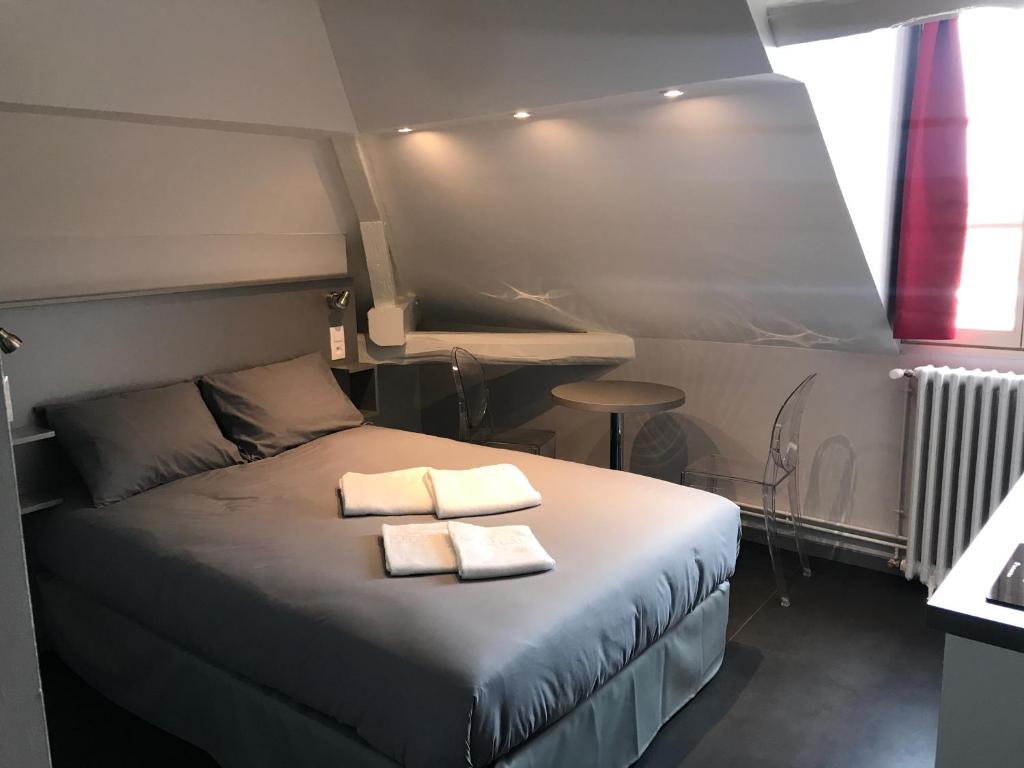 a bedroom with a bed with two towels on it at SmartAppart Troyes in Troyes