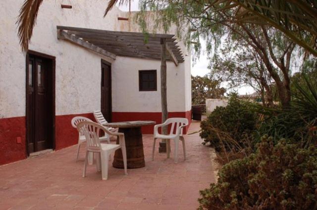 a patio with chairs and a table and a building at GBH Casas Las Portadas in La Oliva