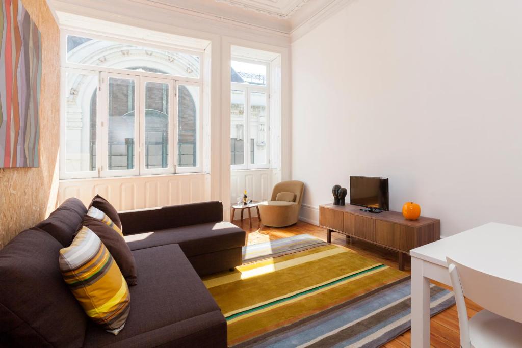 uma sala de estar com um sofá e uma televisão em BO - Sá da Bandeira em Porto