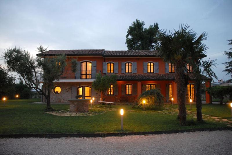 una grande casa con luci accese nel cortile di Ca' Borgo delle Rane a Pernumia