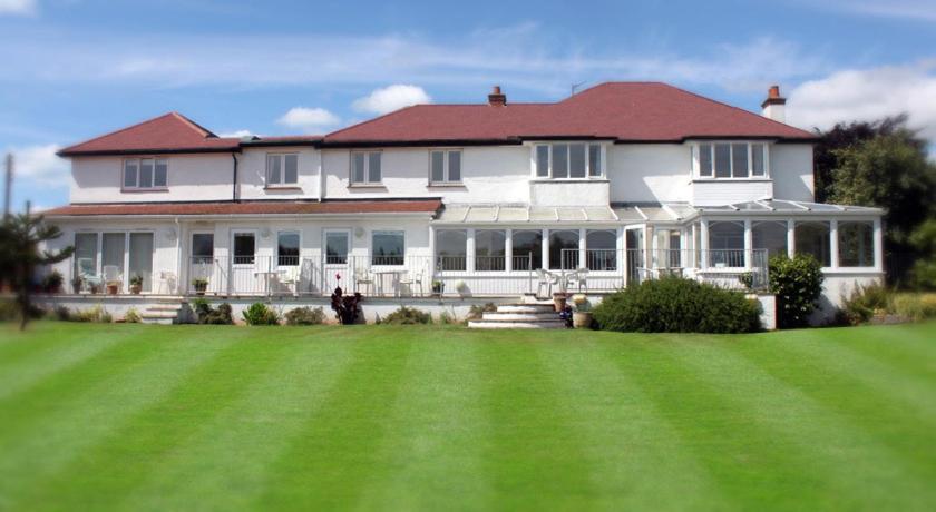 a large white house with a large green lawn at The Long Range in Budleigh Salterton