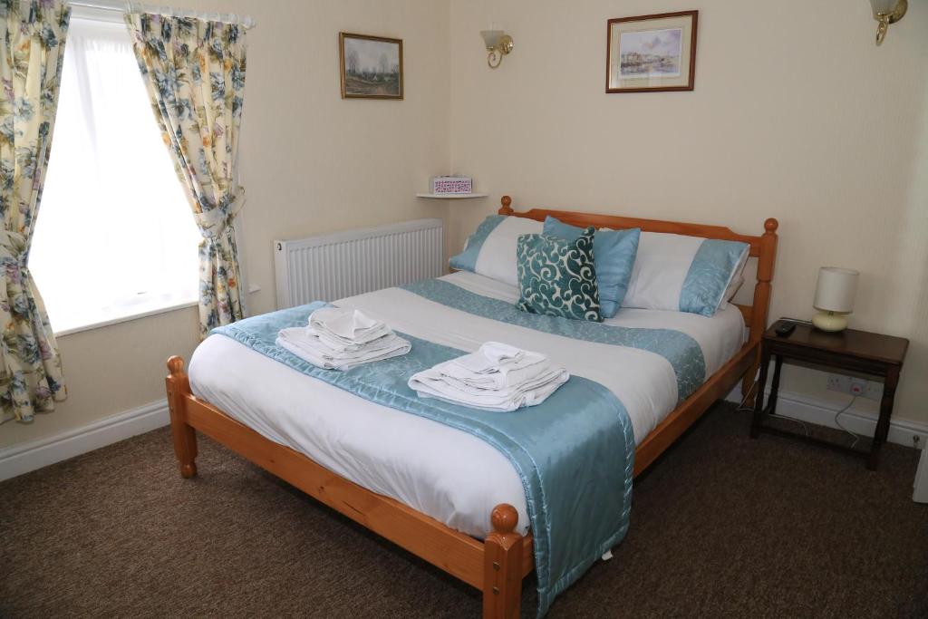 a bedroom with a bed with towels on it at Ladywood House Bed and Breakfast in Ironbridge