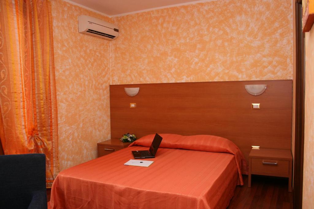 1 dormitorio con 1 cama con ordenador portátil en Elclaca, en Alghero