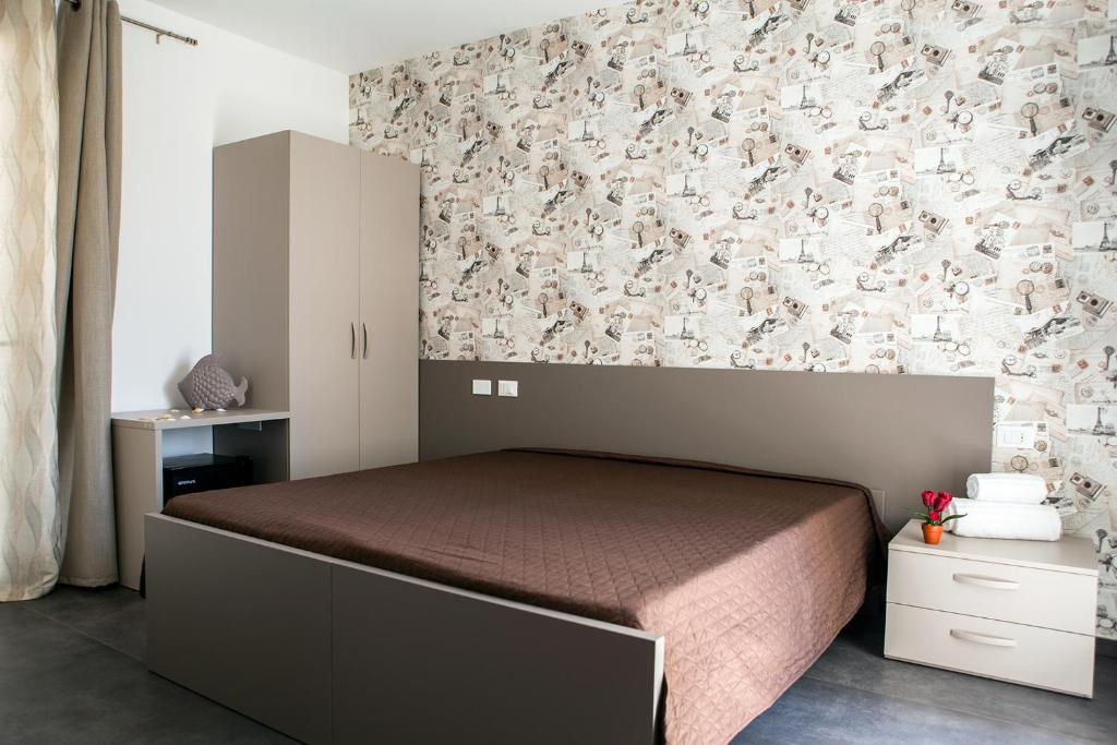 マリーナ・ディ・ラグーザにあるRegina's Homeのベッドルーム1室(ベッド1台付)が備わります。壁紙で覆われたベッドルーム1室を利用します。