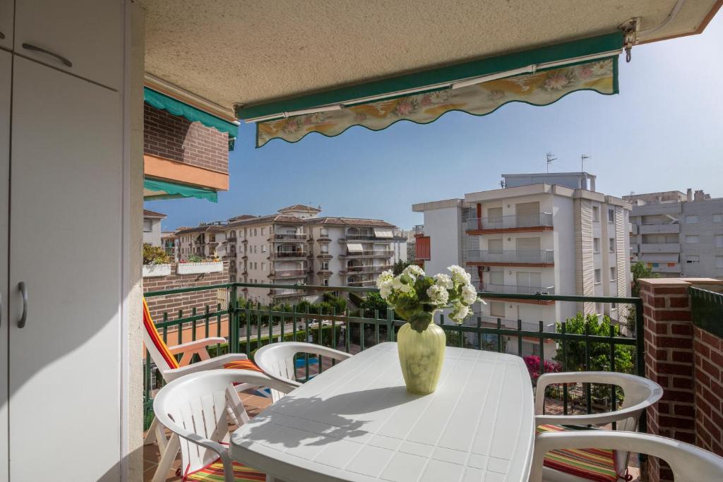 un jarrón de flores sentado en una mesa en un balcón en Calafell Apartment 4, en Calafell