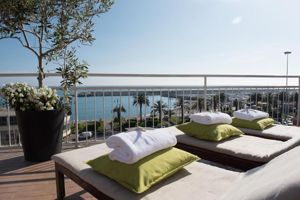 two beds on a balcony with a view of the ocean at Hotel Tigullio in Lavagna