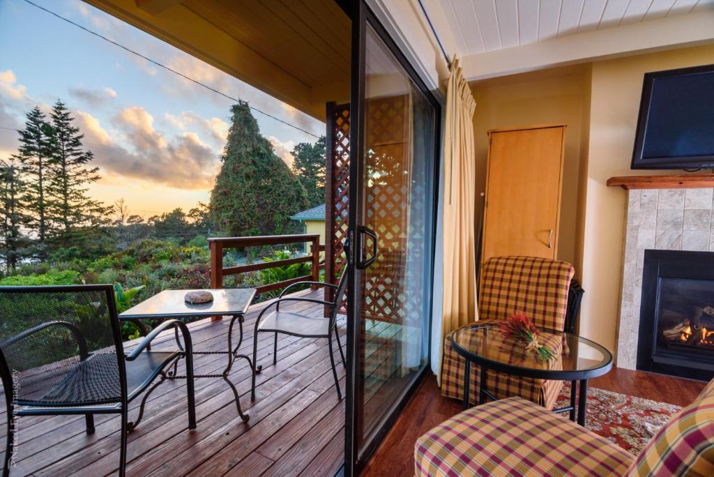 a balcony with a table and chairs and a fireplace at Inn at Buckhorn Cove in Little River