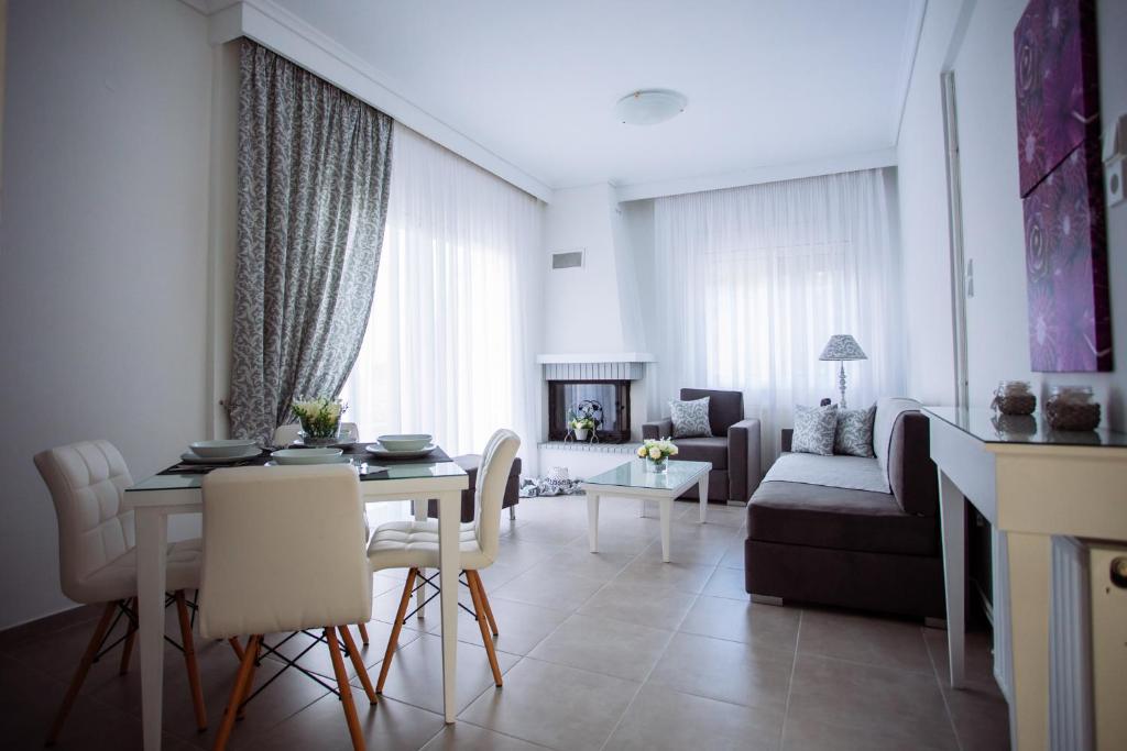 a living room with a table and a couch at Villa Kiza Apartments in Agia Triada