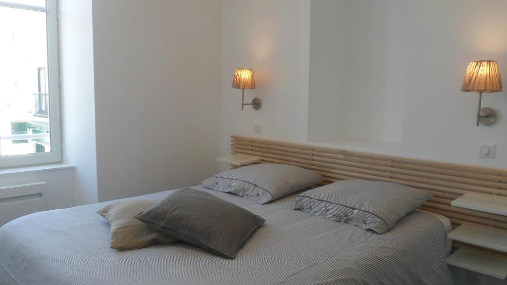 a bedroom with a bed with two pillows on it at Les Halles 1 in La Rochelle